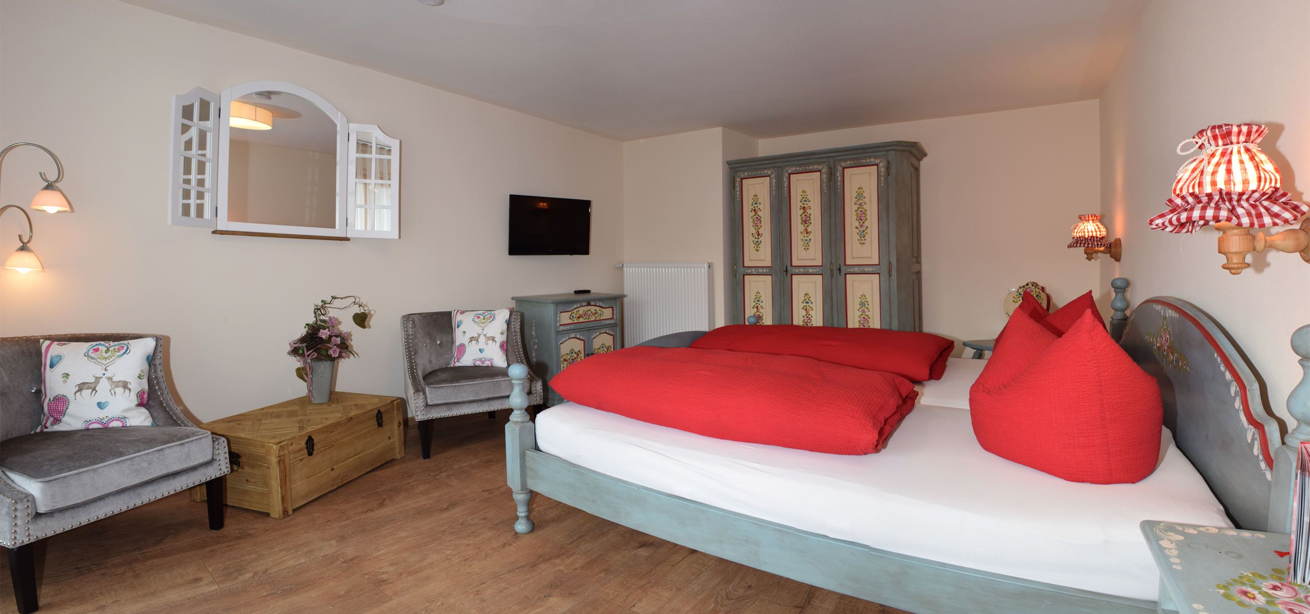 Schlafzimmer mit Doppelbett, TV, Schrank und Sitzecke