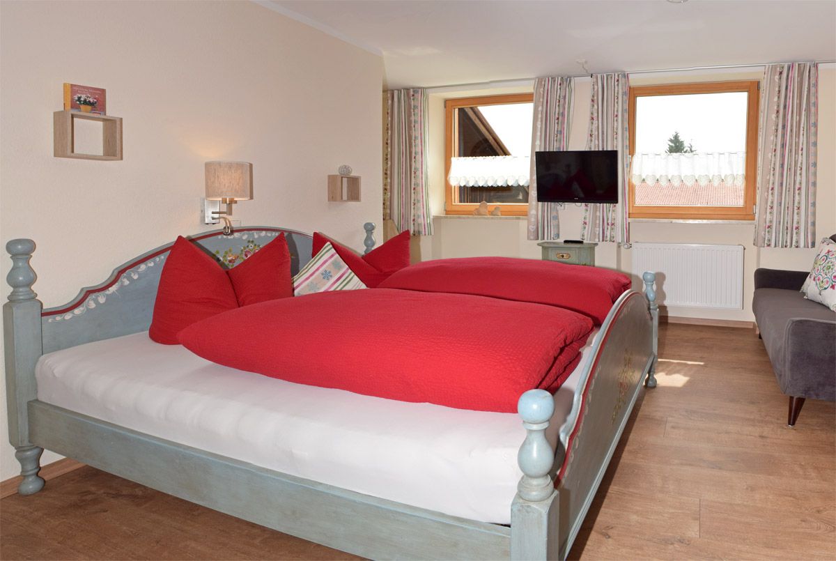 Schlafzimmer mit Doppelbett, Sofa und TV