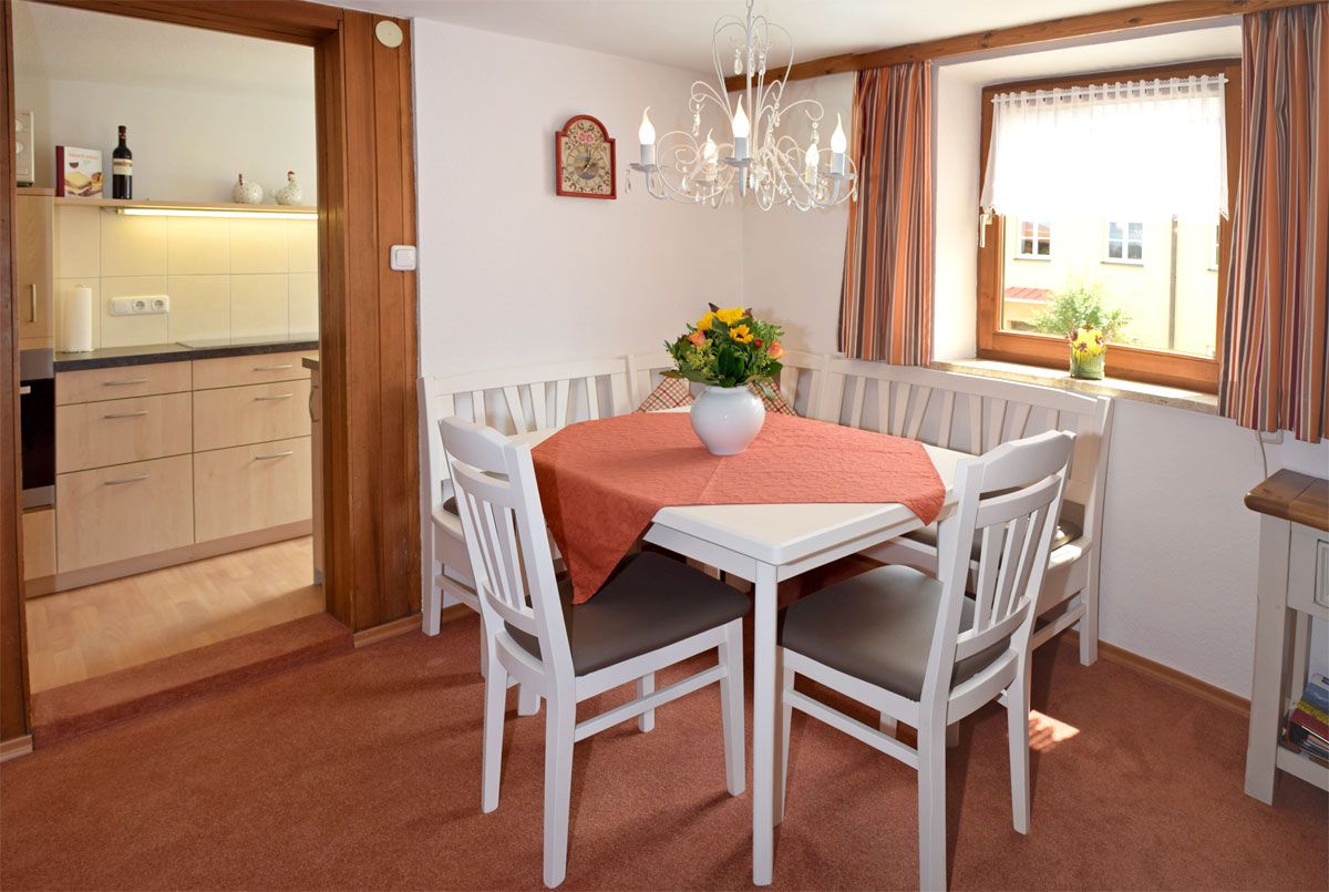 Esstisch mit Stühlen und Eckbank und Zugang zur Küche