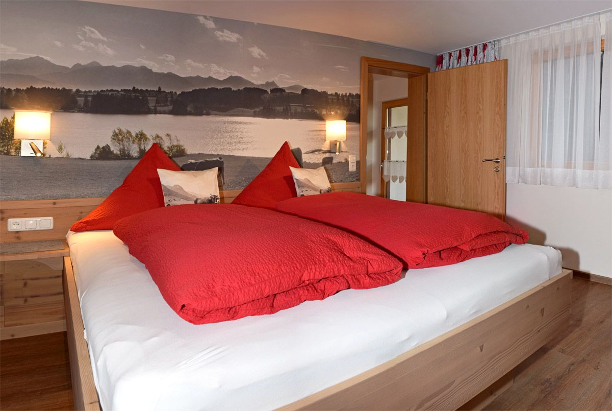 Schlafzimmer mit großem Doppelbett und Panoramabild